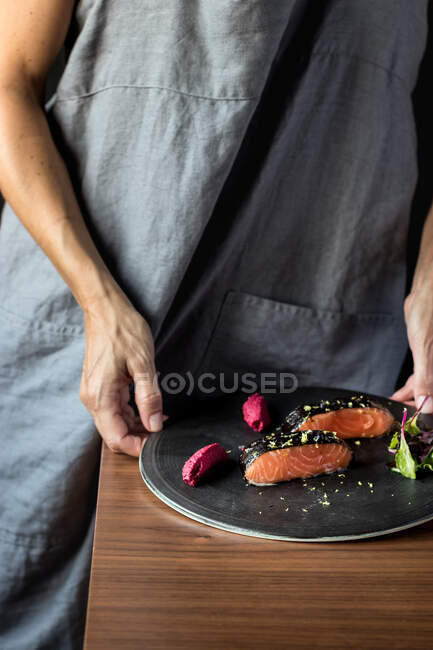Woman preparing delicious candied salmon fillets — Stock Photo