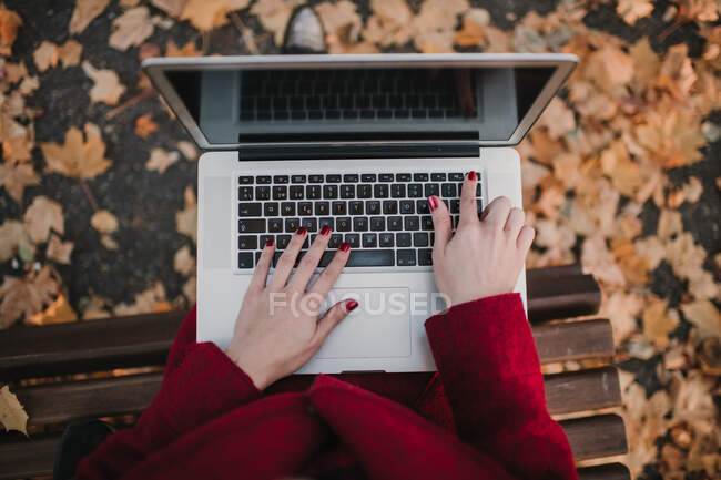 Donna con computer portatile seduta su panca — Foto stock