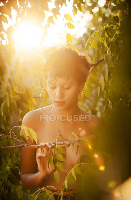 Atractivo topless joven hembra posando en el jardín - foto de stock
