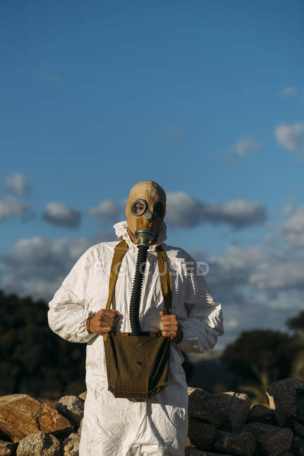 Hombre con máscara de gas lacrimógeno y traje científico blanco - foto de stock