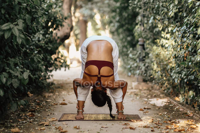 Mulher descalça realizando Headstand no caminho no jardim de outono — Fotografia de Stock