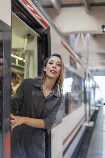 Mulher inclinada para fora trem na estação — Fotografia de Stock