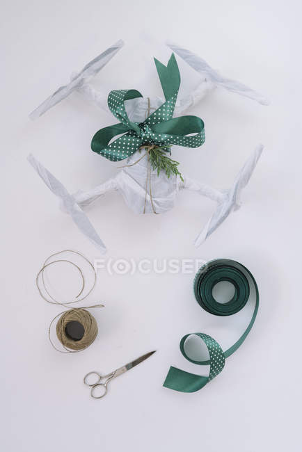 Drone wrapped as Christmas gift with green ribbon on white background — Stock Photo
