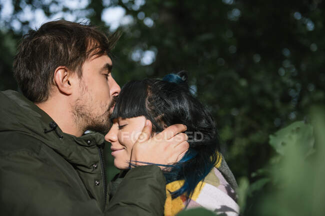 Пара в лісі дивиться один на одного і цілується — стокове фото