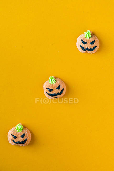 Doces de Halloween em forma de abóbora no fundo laranja — Fotografia de Stock