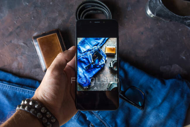 Аерофотозйомка чоловічого джинсового одягу з гаманцем, браслет для штрихів, смартфон. і чорне шкіряне взуття — стокове фото