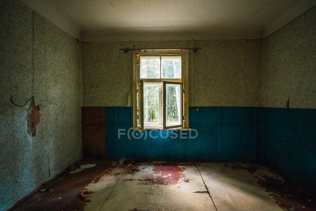 Vista de la habitación vacía con paredes de mala calidad y el suelo en el edificio abandonado de edad - foto de stock