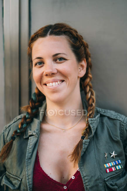 Portrait d'une jeune femme aux cheveux roux souriante avec des tresses — Photo de stock
