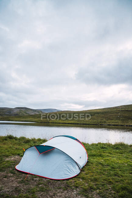 Tent in mountain lake — Stock Photo