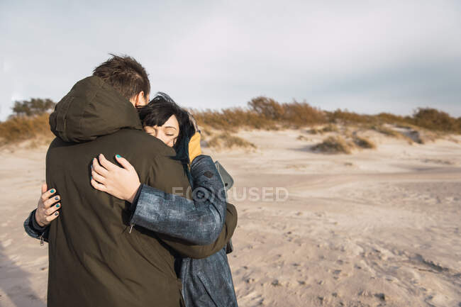 Пара на відкритому повітрі обіймається на пляжі — стокове фото