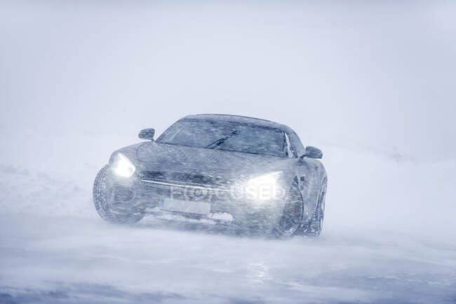 Luxury car in snowy road — Stock Photo