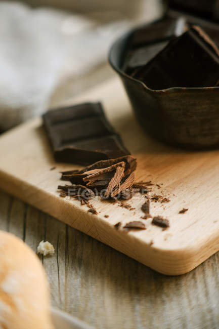Dark chocolate chunks on wooden chopping board — Stock Photo