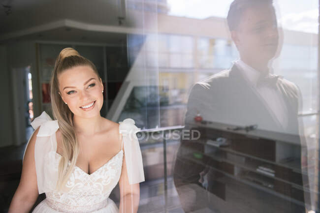 Noiva olhando para noivo através de uma janela — Fotografia de Stock
