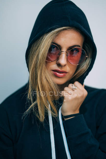 Молода блондинка в сонцезахисних окулярах дивиться на камеру — стокове фото