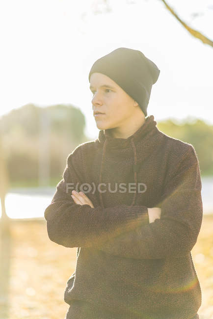 Portrait of teenage boy standing outdoors with arms crossed — Stock Photo