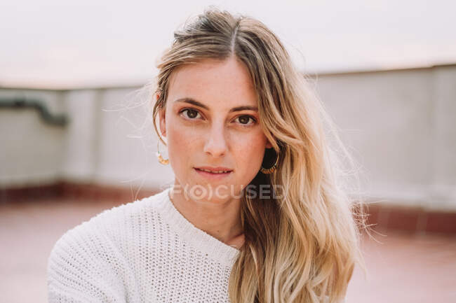 Beautiful woman with fair hair posing on rooftop — Stock Photo