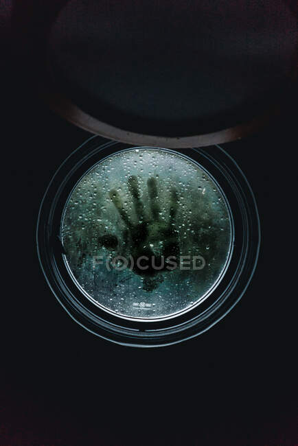 Print of human hand on glass of wet round porthole in New Zealand — Stock Photo