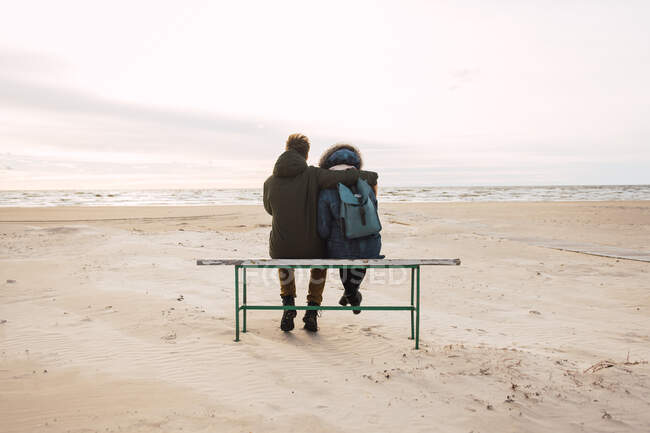 Пара сидить, дивлячись на море — стокове фото