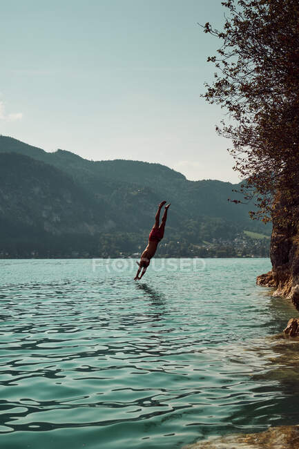 Hombre saltando en el agua - foto de stock