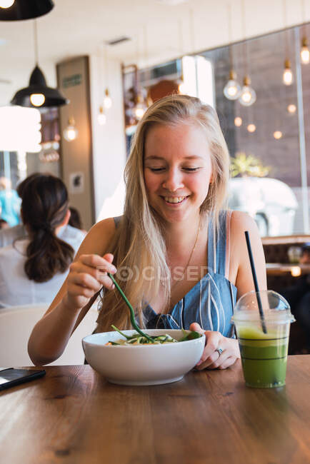 Femme prenant un verre et un repas dans un café — Photo de stock