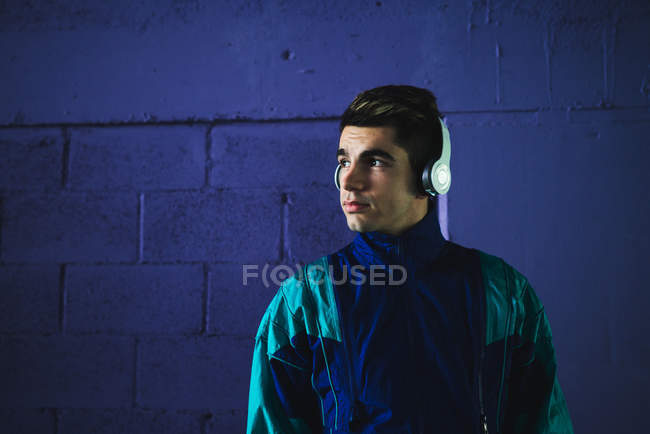Young man in sportswear listening to music with headphones — Stock Photo