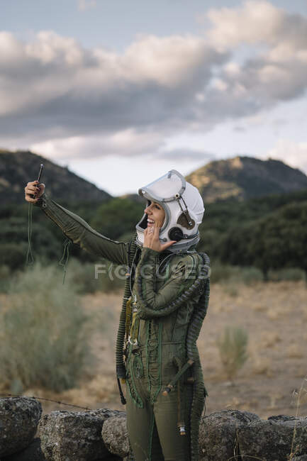 Beautiful female astronaut with mobile phone. — Stock Photo