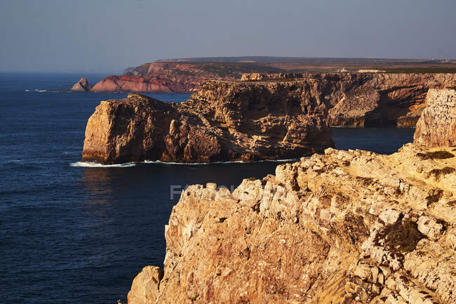 Морское побережье с высокими скалами и голубой водой — стоковое фото