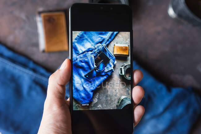 Vue aérienne de vêtements en denim pour hommes avec portefeuille, bracelet en tack, smartphone. et chaussures en cuir noir — Photo de stock