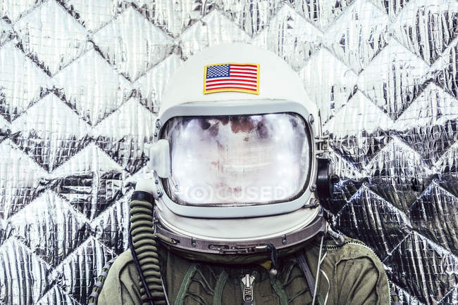 Pessoa vestindo trajes de espaço antigo e capacete contra fundo folha — Fotografia de Stock