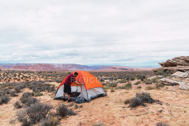 Reisender packt Rucksack und schließt Zelt — Stockfoto