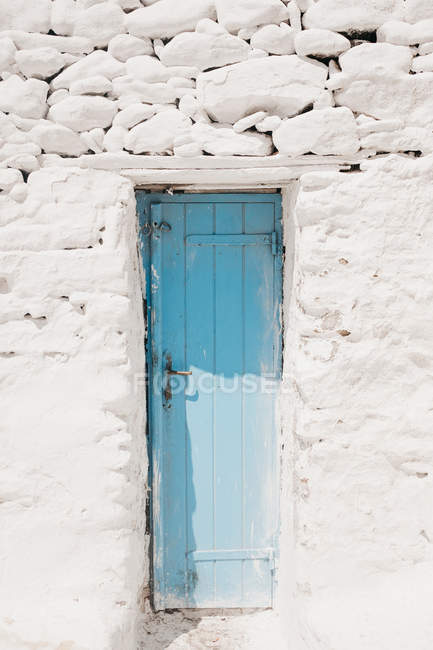 Kleine azurblaue alte Tür in weißer Felsenkonstruktion in Mykonos, Griechenland — Stockfoto