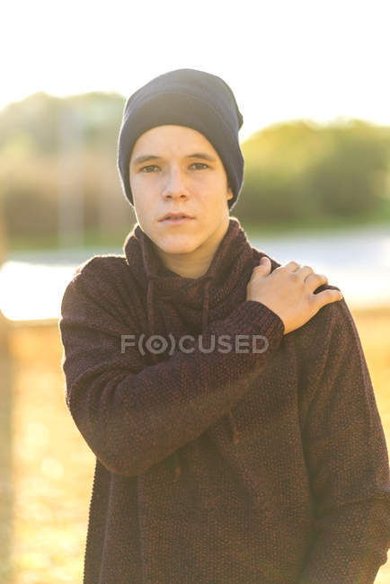 Portrait d'un adolescent en chapeau et sweat à capuche debout à l'extérieur — Photo de stock