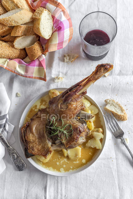 Agnello arrosto con patate servito su piatto su tovaglia bianca — Foto stock