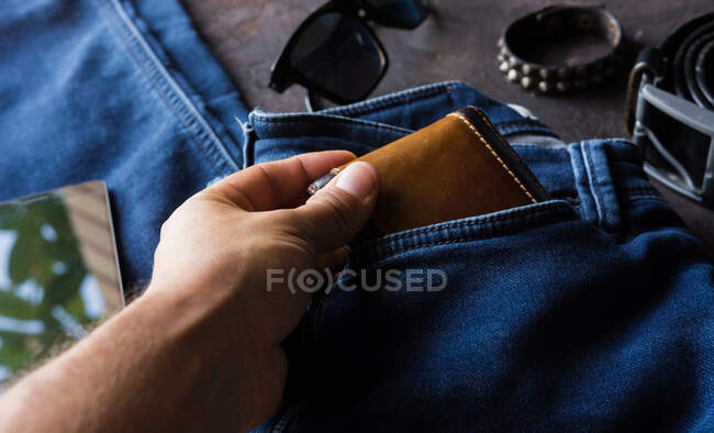 Aerial view of mens denim clothing with wallet, tack bracelet, smartphone. and black leather shoes — Stock Photo