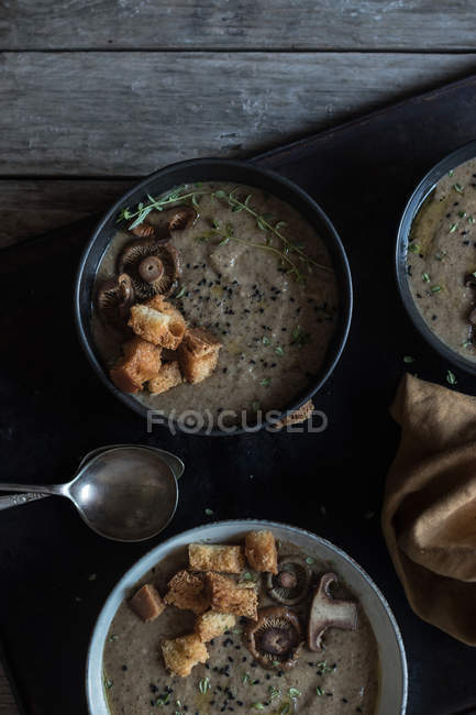 Mushroom cream soup with croutons in bowls on tray on wooden table — Stock Photo