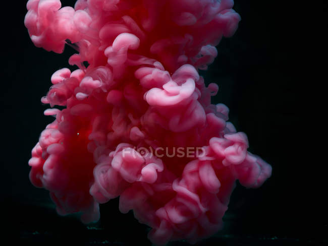 Nuage rose fumé abstrait avec tourbillons sur fond noir — Photo de stock