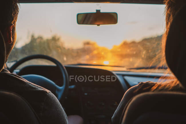 Куст мужчина и женщина, сидя внутри современного автомобиля во время путешествия по Болгарии в вечернее время — стоковое фото