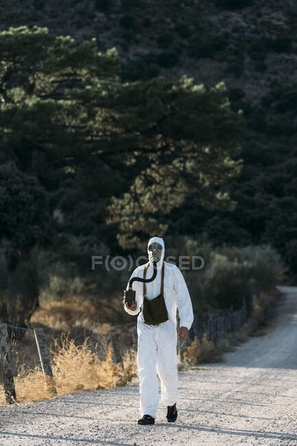 Чоловік зі сльозогінною газовою маскою та білим костюмом вченого — стокове фото