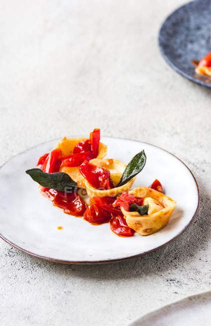 Délicieux plat de tortellini aux tomates servi sur plaque grise — Photo de stock