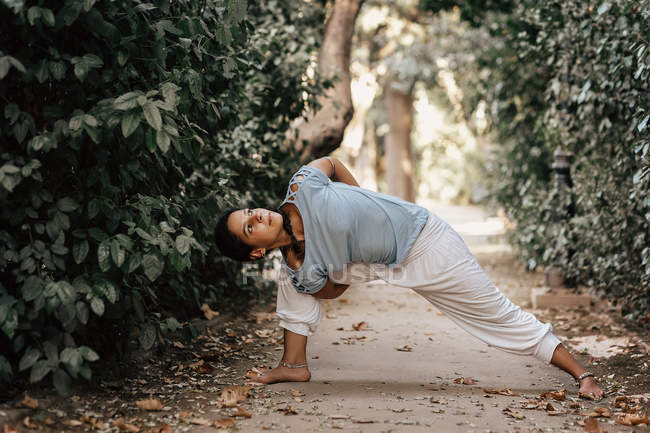 Femme mince faisant du yoga sur ruelle dans le parc d'automne — Photo de stock