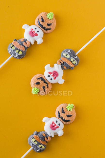 Caramelle di Halloween su bastoncini su sfondo arancione — Foto stock