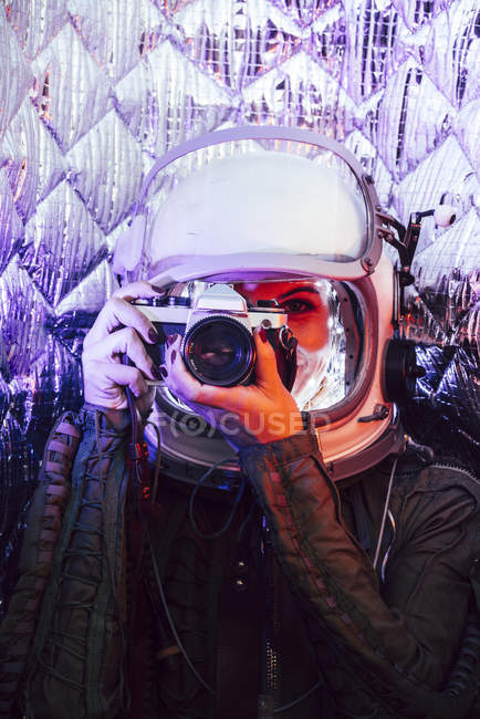 Menina vestindo capacete antigo espaço e traje segurando câmera de fotos — Fotografia de Stock