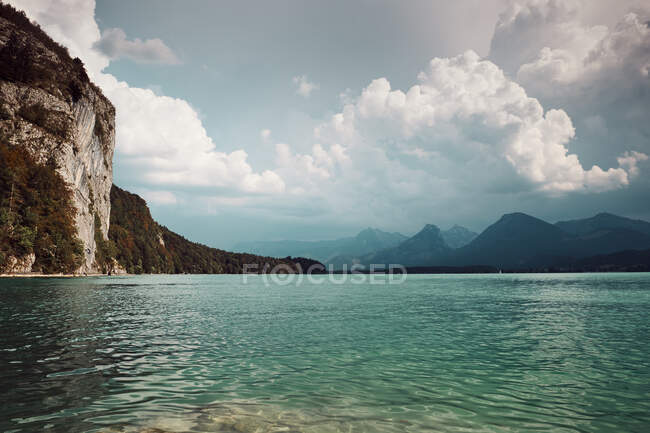 Traumhafter Blick auf den See mit klarem Wasser zwischen Bergen und wolkenverhangenem Himmel in Österreich — Stockfoto