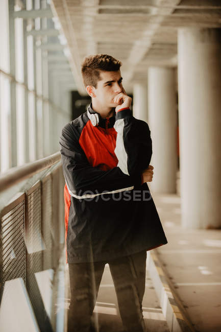 Молодий вдумливий чоловік стоїть всередині будівлі зі стовпами — стокове фото