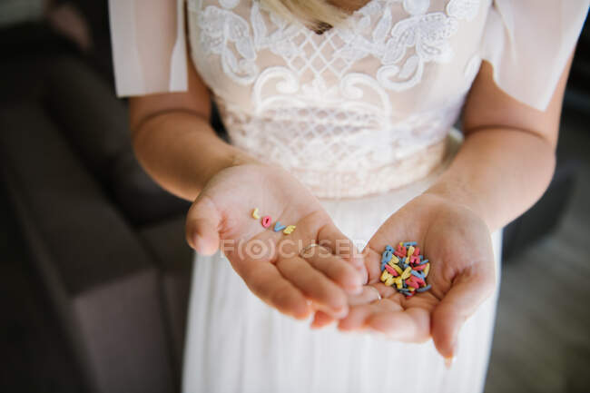 Crop bride in white beautiful gown holding love colorful letters — Stock Photo