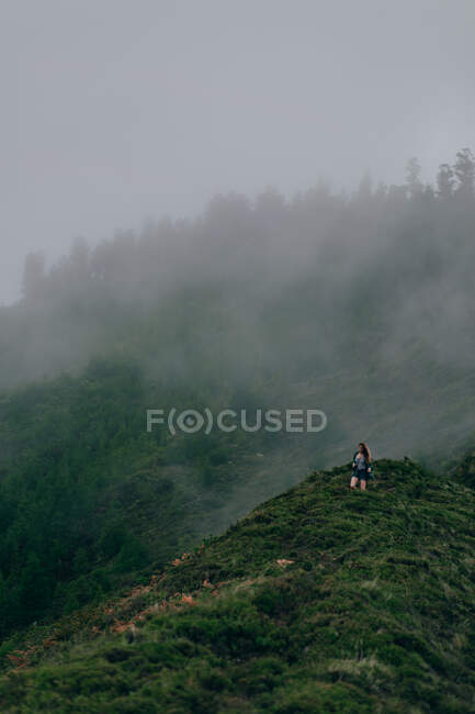 Mulher andando na colina verde — Fotografia de Stock