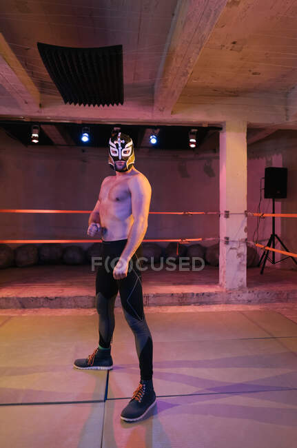Erwachsener muskulöser Mann trägt Wrestlermaske und steht mit gekreuzten Händen am Ring — Stockfoto