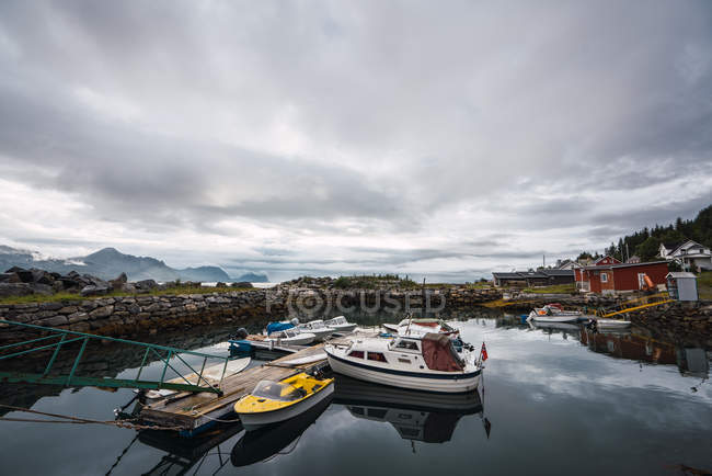 Boats floating on lake in mountains under cloudy sky — Stock Photo