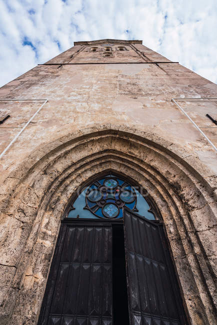 Schäbige Mauer der alten Kirche vor wolkenverhangenem Himmel — Stockfoto