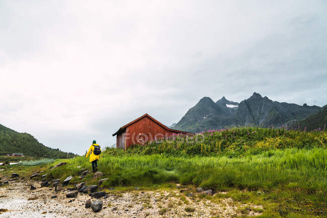 Turista con zaino sulla riva rocciosa — Foto stock